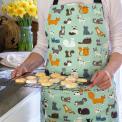 Nine Lives Recycled Cotton Apron worn by adult holding baked goods