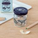 Glass jar pencil sharpener with dinosaurs print on desk with pencils