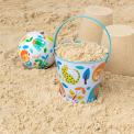 Wild Wonders tin bucket containing sand alongside play ball and sandcastles