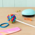 Multi-coloured hairbands on lollipop stick on table with hair clips, hair brush and comb