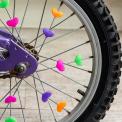 Colourful spoke hearts attached to a bicycle wheel, representing cycling-themed gifts.