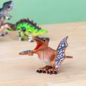 Pterodactyl wind up toy and a green Stegosaurus in the back