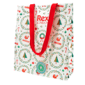 Festive Christmas design shopping bag with red handles and a tag 