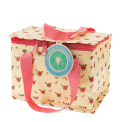 Insulated lunch bag decorated with a floral pattern and featuring a tag