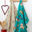 Cotton tea towel with a festive holiday design hanging on a hook