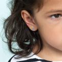 Stick-on earrings in rainbow shape on a kid’s ear