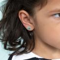 Stick-on earrings in butterfly shape on a kid’s ear