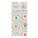 Cotton tea towel with a festive holiday design featuring Christmas trees, wreaths in a packaging