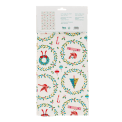 Cotton tea towel with a festive holiday design featuring Christmas trees, wreaths in a packaging