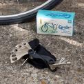 Cyclist multi-tool set with various attachments placed beside a bicycle wheel and a box