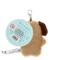 dog-shaped plush keyring wearing a tie with brown ears and a tag with safety warnings
