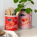 Two large Cherry tins used as utensil holder and plant pot.
