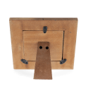 Back of a wooden square picture frame with black metal clips and a stand