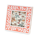 Square pink picture frame with white leaf patterns on the border.