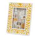 picture frame with a mustard yellow border and white leaf patterns