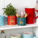 Mini honey storage tins repurposed as herb and utensil holders on a kitchen shelf.