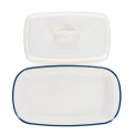 Rectangular white enamel butter dish with a blue rim, shown with the lid on the side