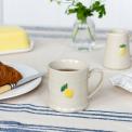 Stoneware mug featuring a yellow lemon print with green leaves and handle 