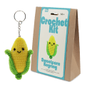 Crochet kit packaging displayed next to a finished yellow and green leaf sweetcorn keychain