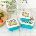 Three plastic snack boxes in turquoise and cream featuring floral pattern