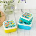 Three plastic snack boxes in yellow light blue turquoise and cream featuring prints of butterflies amongst flowers
