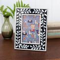 picture frame with a navy blue border and white leaf patterns