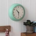 Round mint green wall clock with black hands and numbers