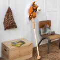 hobby horse toy with white mane and black bridle on a wooden stick