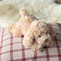 Light brown plush dog toy lying down with floppy ears and soft fur