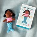 Mini mermaid soft toy placed beside a small illustrated box with mermaid design