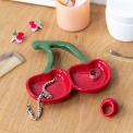 Red ceramic trinket dish shaped like two cherries with green stems displayed with ring and bracelet. 