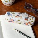 glasses case with playful dog illustrations resting on a notebook beside a pair of glasses.