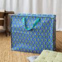 Large blue storage bag with green floral pattern and turquoise handles.