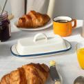 Rectangular white enamel butter dish with a blue rim and a handled lid
