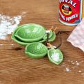 Set of four ceramic measuring spoons shaped like green leaves with brown stem handles 