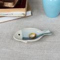 Blue and white ceramic fish‑shaped trinket dish displayed with ring.