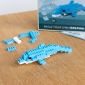 Completed dolphin brick model displayed beside its packaging box.