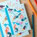 Notebook with illustrated mermaids, sea creatures, and shells on a light aqua cover.