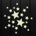 Glow‑in‑the‑dark star shapes in different sizes on a black background.