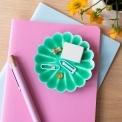 Green enamel flower-shaped trinket dish holding clips and small items