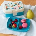 Lunchbox with mermaid design and tray of fruits and macarons beside a pear.