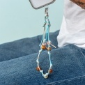 Blue and tan cord phone strap with decorative beads shown hanging from a phone