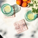 Set of two ceramic drinks coasters featuring an elegant embossed pattern, reminiscent of traditional tile designs.