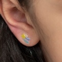 Stick-on earrings in rainbow shape on a kid’s ear