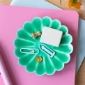 Green enamel flower-shaped trinket dish holding clips and small items