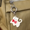 Cream cat-shaped keyring with red bow and silver ring attachment.