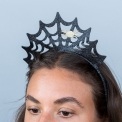 Black glitter spiderweb headband with a gold spider decoration.
