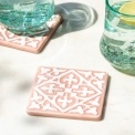 Set of two ceramic drinks coasters featuring an elegant embossed pattern, reminiscent of traditional tile designs.
