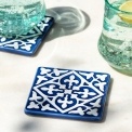 Blue ceramic tile coasters with white pattern shown beside two glasses of lemon water.