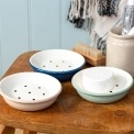 Round two-part soap dish with drainage holes in different colour.